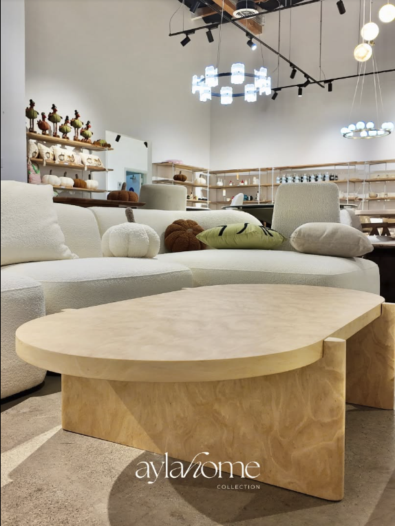 Wide view of the Ayla Home Collection San Jose showroom with pendant lighting, boucle sofa, and burl wood coffee table