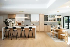Open kitchen and dining area with a round wood table set for guests